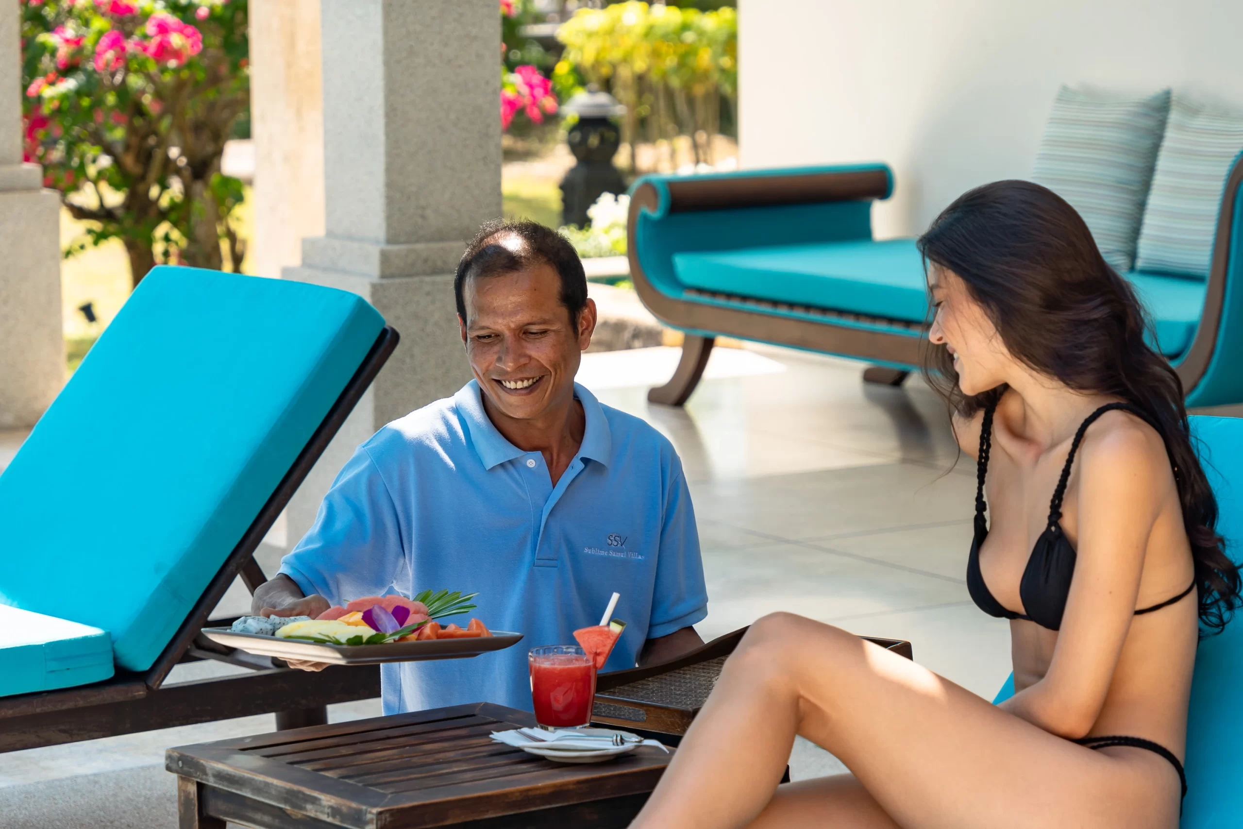 villa staff serving with fruits and drinks to a lady customer